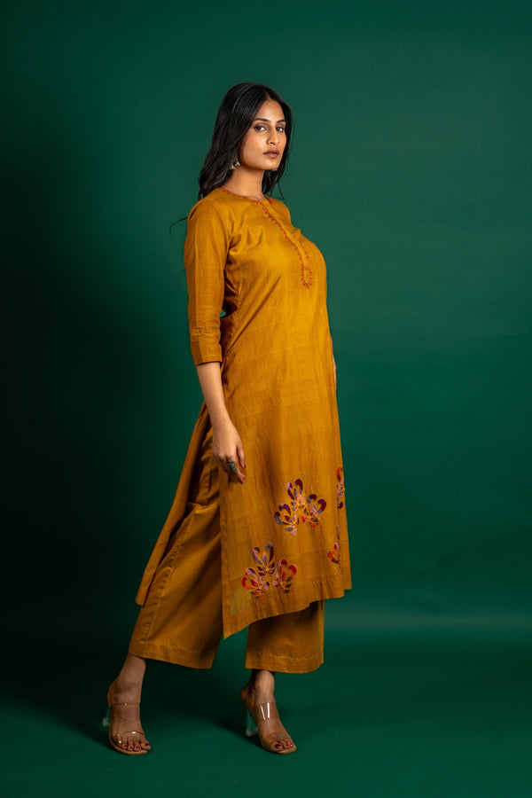 Mustard A-line handloom top with thread work on neck, the Daman is highlighted with appliqué work and sequin detailing, and cotton pant