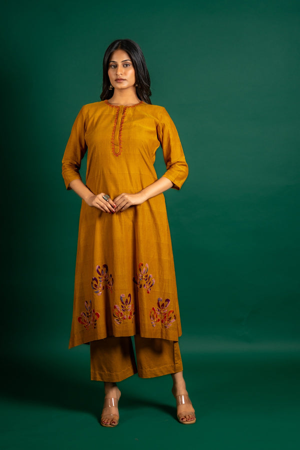 Mustard A-line handloom top with thread work on neck, the Daman is highlighted with appliqué work and sequin detailing, and cotton pant