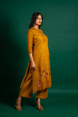 Mustard A-line handloom top with thread work on neck, the Daman is highlighted with appliqué work and sequin detailing, and cotton pant