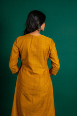Mustard A-line handloom top with thread work on neck, the Daman is highlighted with appliqué work and sequin detailing, and cotton pant