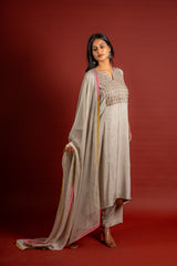 Beige silk top with self-woven butta detailing, with panel and a yoke heavy thread work and sequin embellishments, chiffon dupatta with work and colourful lace detailing, and rayon pant