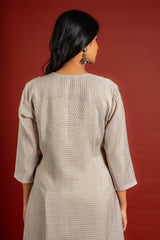 Beige silk top with self-woven butta detailing, with panel and a yoke heavy thread work and sequin embellishments, chiffon dupatta with work and colourful lace detailing, and rayon pant