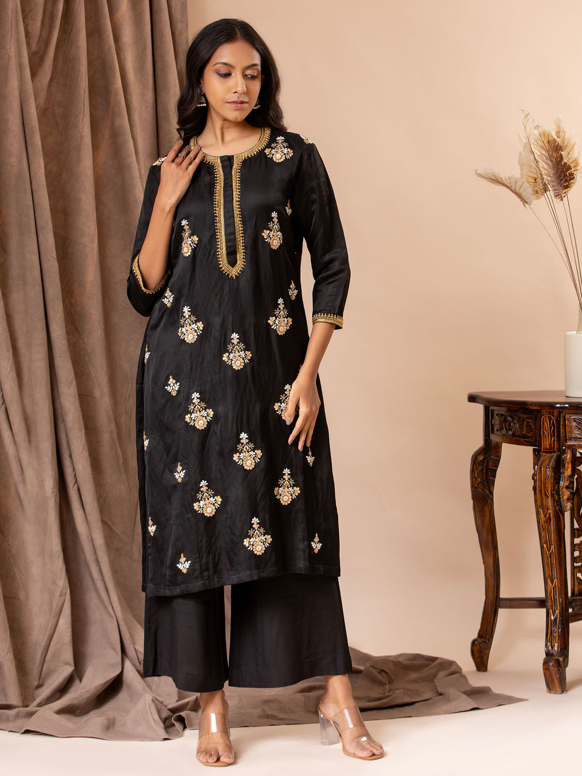 Black linen satin straight-cut top with Gota Patti and threadwork bhutis, paired with rayon pants.