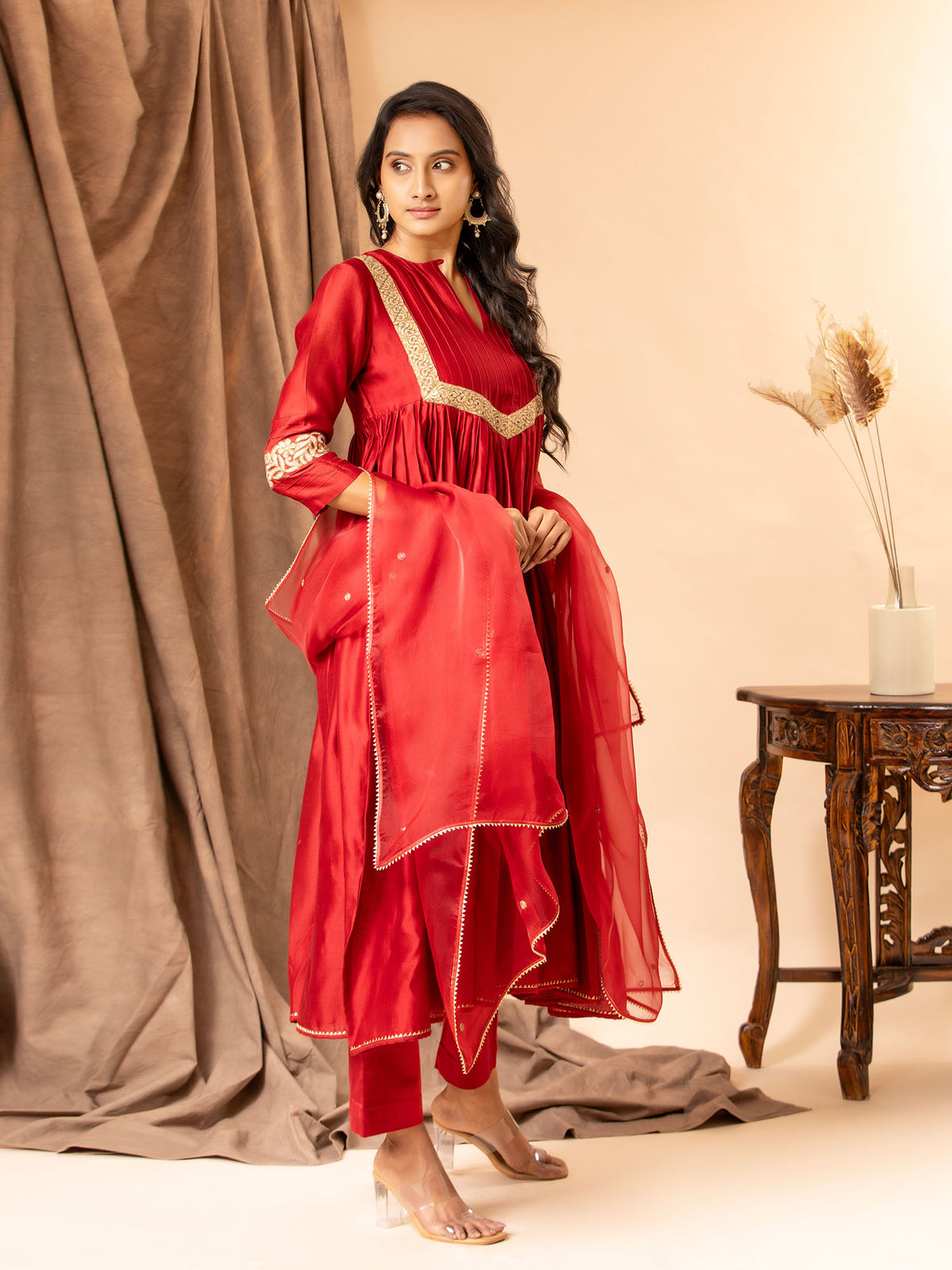 Crimson red Chanderi top with kali and gathered design, featuring golden detailing on the yoke and sleeves. paired with an organza dupatta