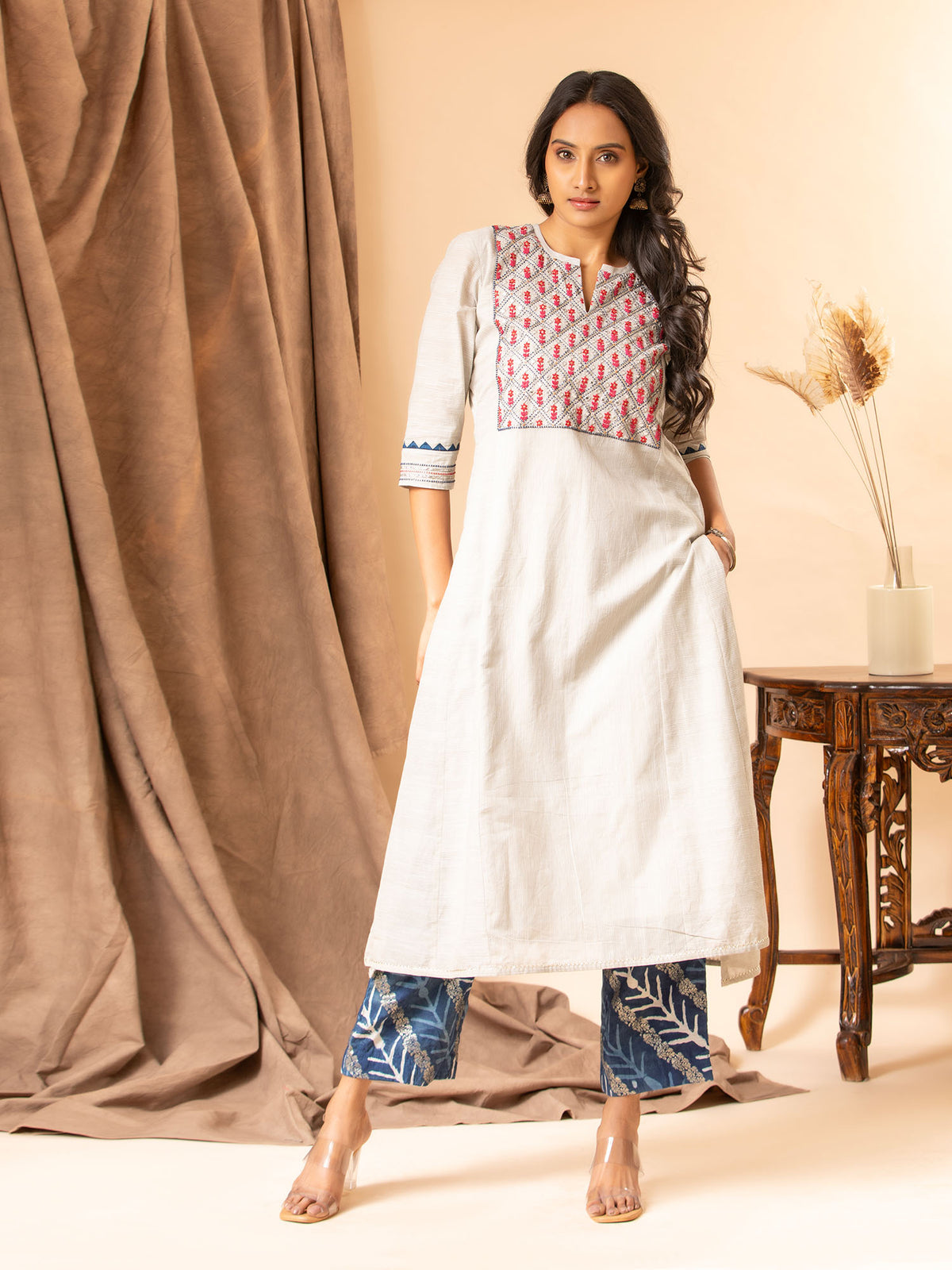 Handwoven light grey A-line panel top with handwork yoke featuring thread and mirror work, paired with blue printed pants