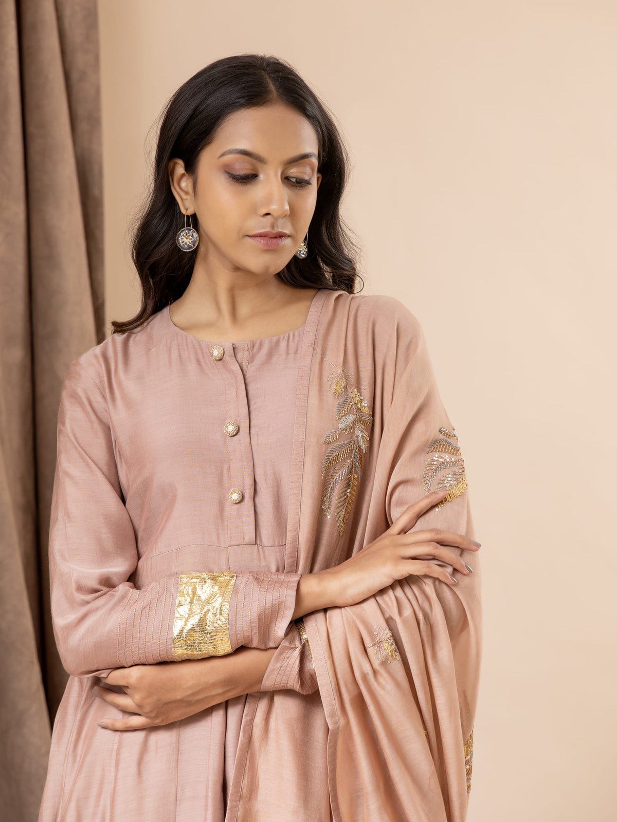 Muted sand pink muslin top with Gota detailing on the sleeves, paired with a intricate feather detailing handembroidered dupatta