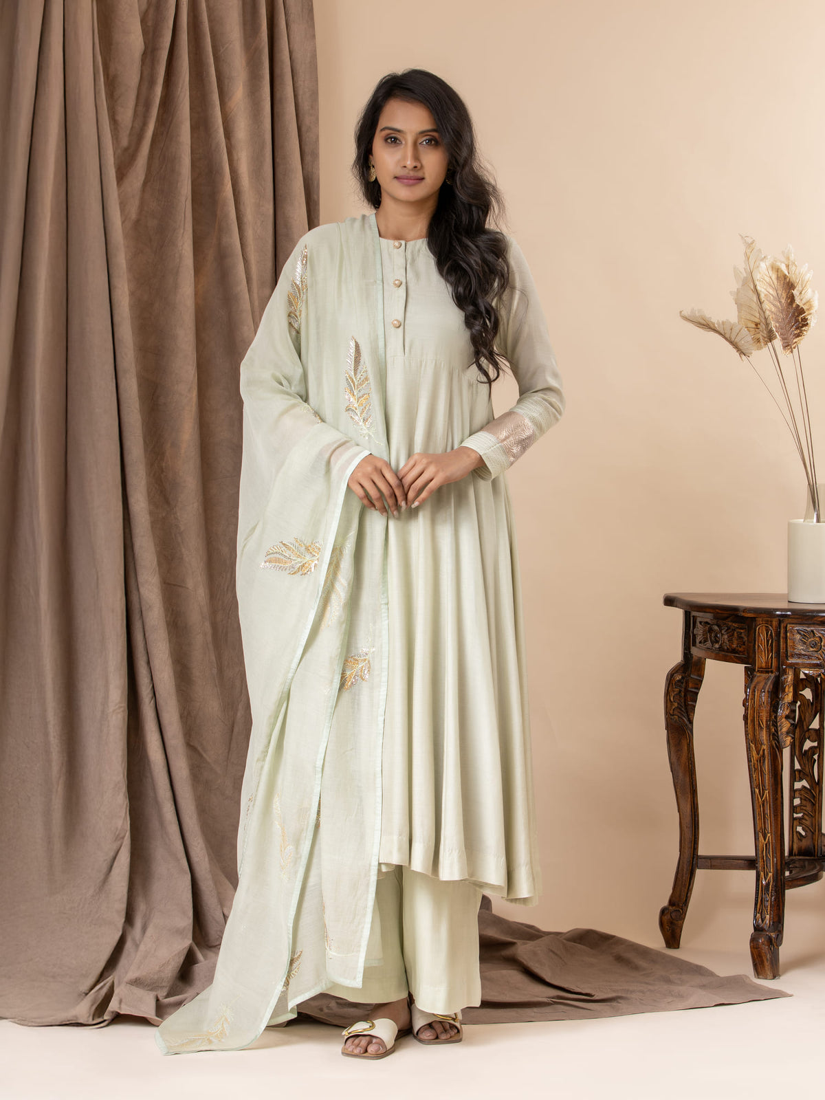 Powder green muslin top with Gota detailing on the sleeves, paired with an intricate feather detailing hand-embroidered dupatta