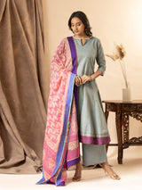 Slate blue handwoven kali top with a pink printed Kota dupatta highlighted with sequins, paired with loose pants. The top features an intricate hand-embroidered neckline