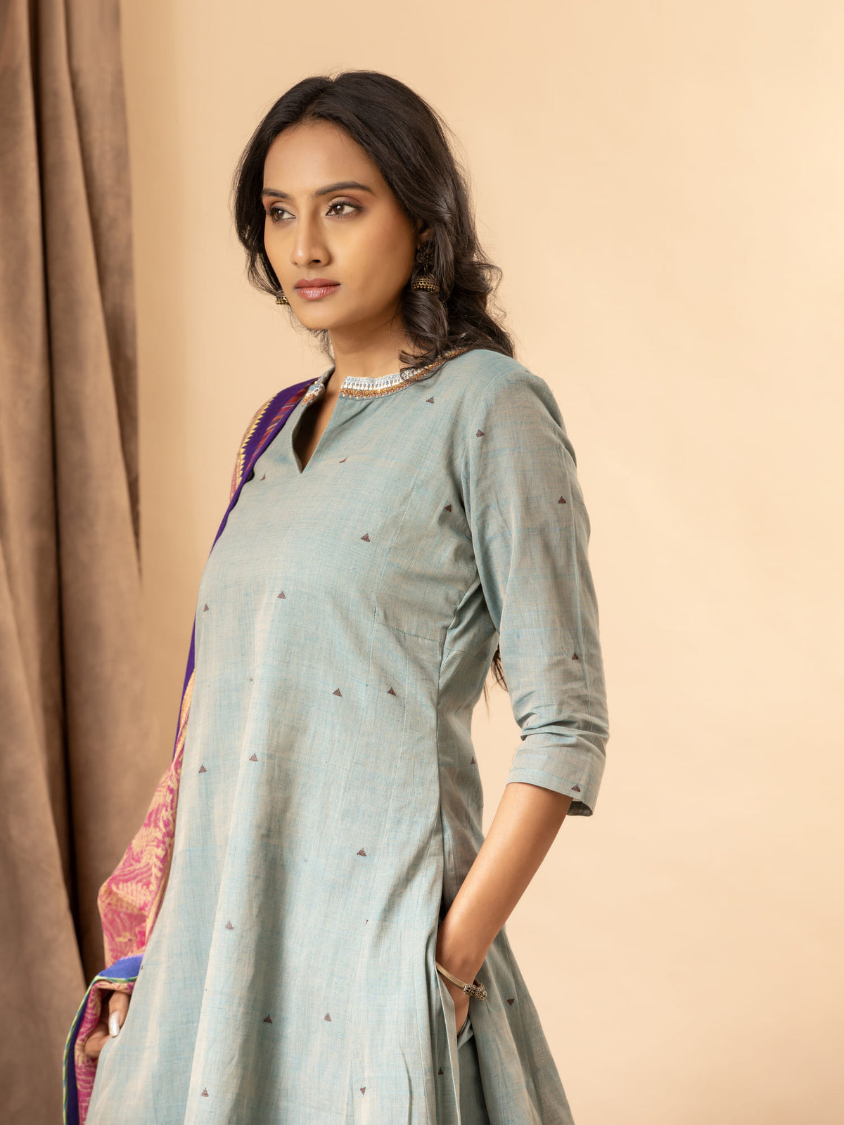 Slate blue handwoven kali top with a pink printed Kota dupatta highlighted with sequins, paired with loose pants. The top features an intricate hand-embroidered neckline