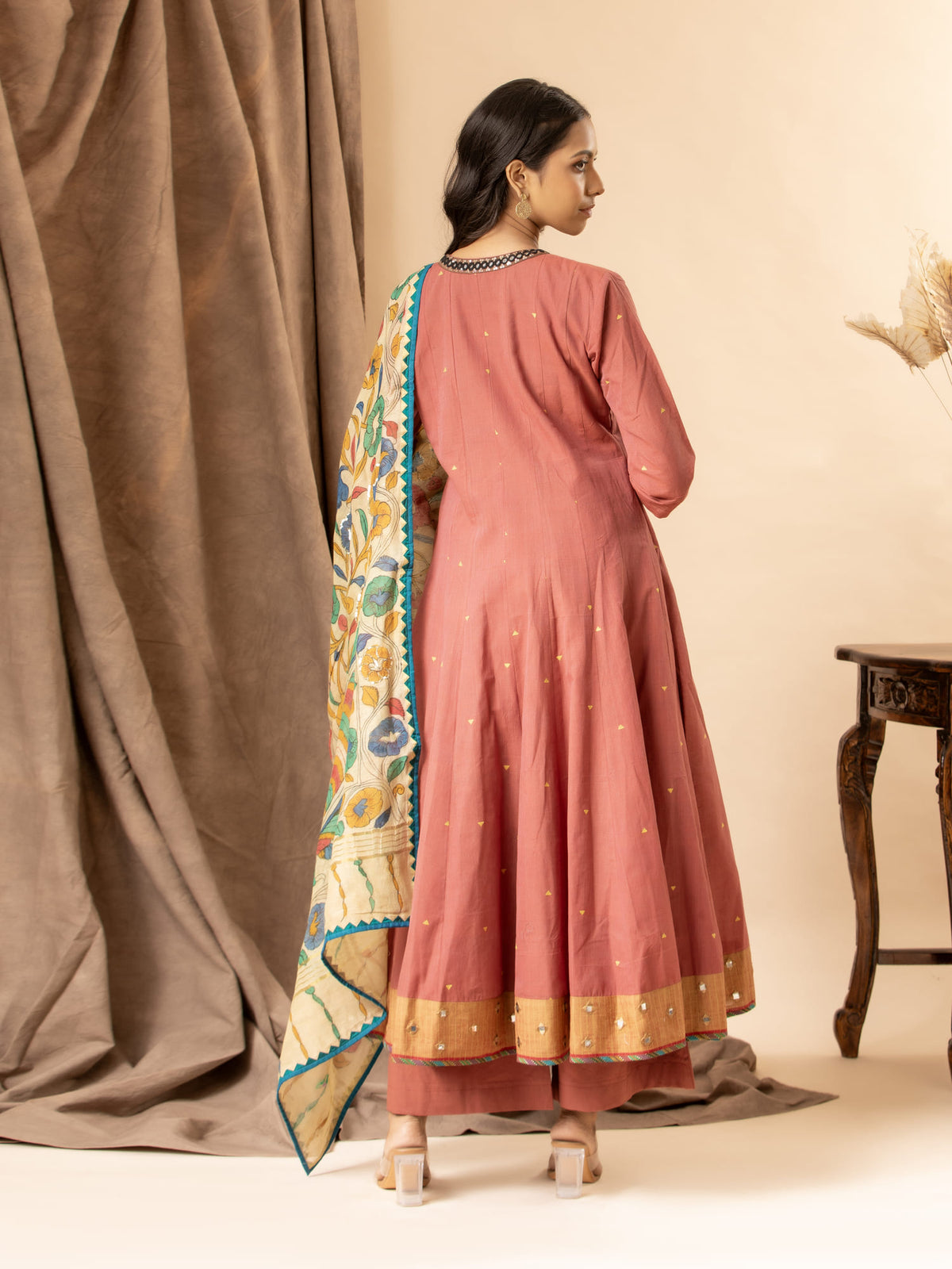 Warm terracotta handwoven top with mirror work on the neckline, paired with a Kalamkari dupatta and matching pants