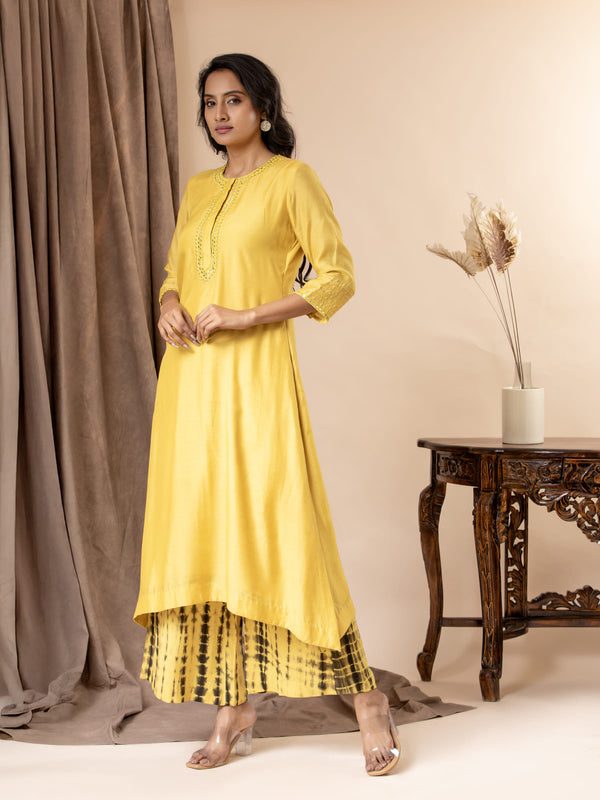 Yellow muslin top with thread and mirror work detailing, paired with Shibori tie-and-dye pants