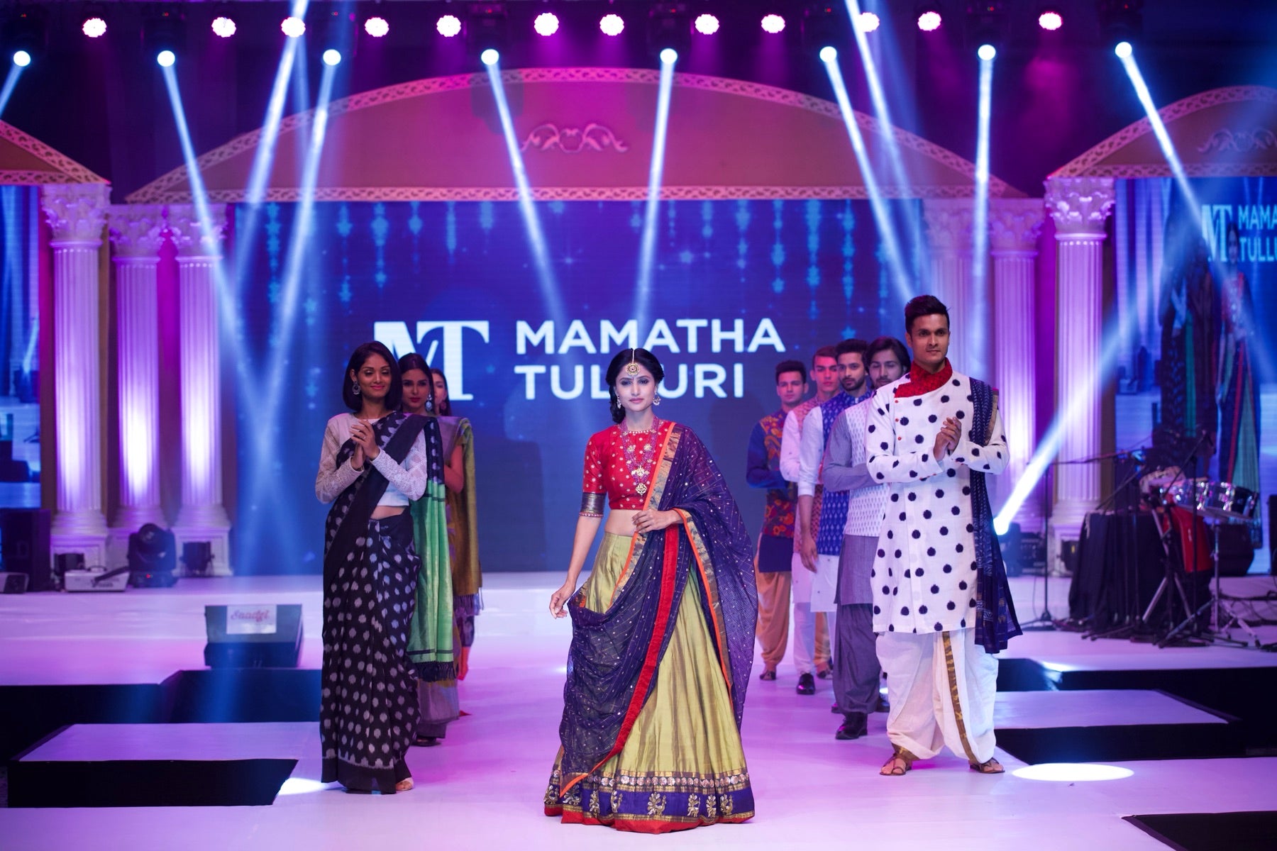 Finale walk, models and designer on the runway under the MT branding