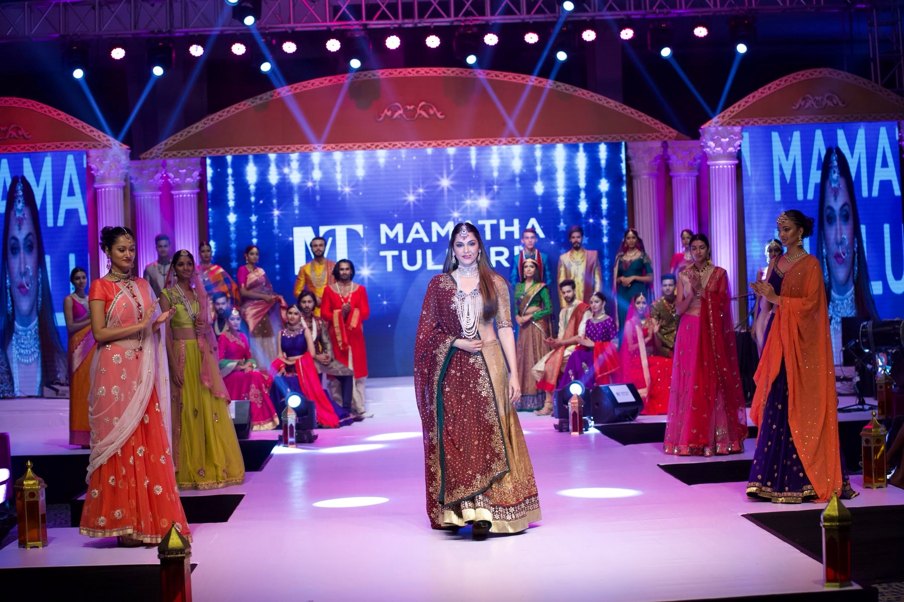 Model in a maroon bridal lehenga closing the runway walk