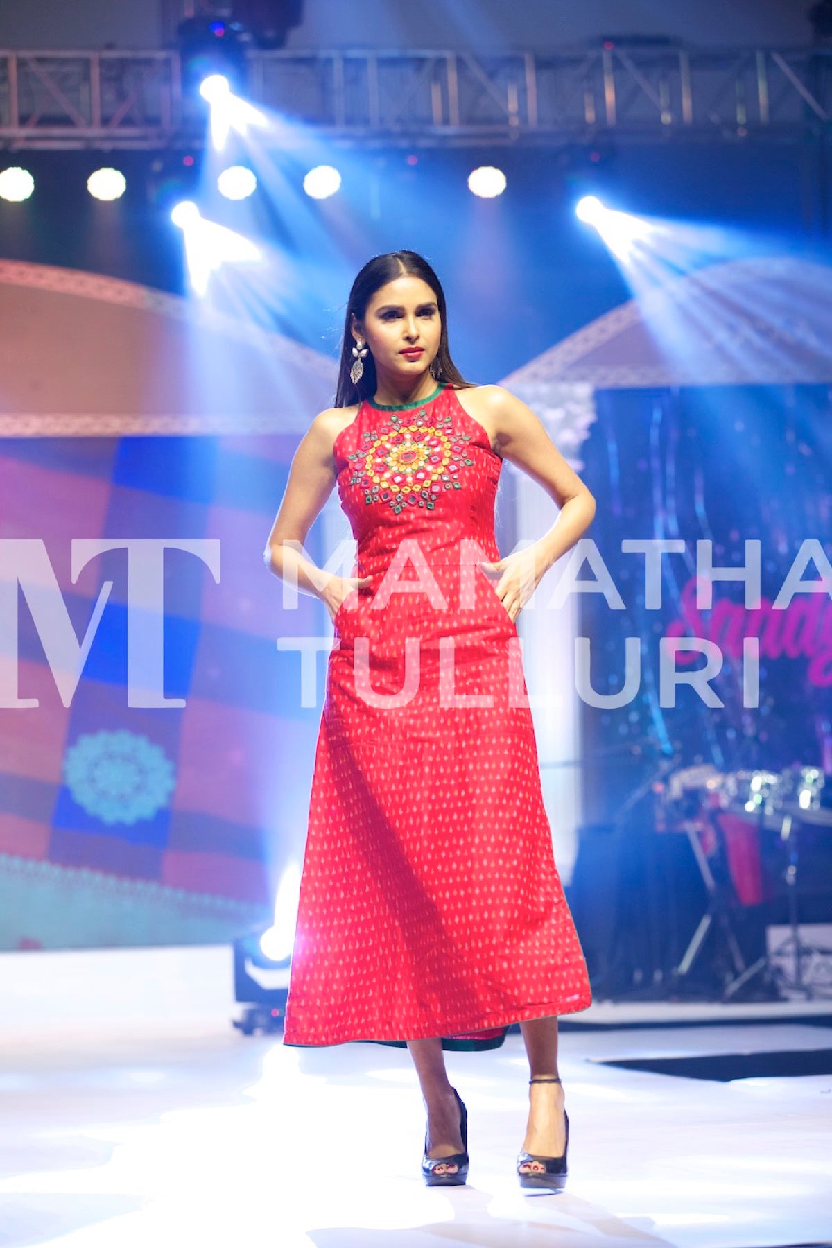 Model in a red sleeveless dress on the runway
